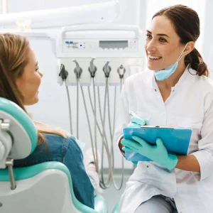 A-dentist-explaining-a-procedure-to-a-woman-sitting-in-a-dental-chair